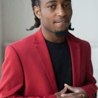 a young man in a red suit posing for a photo